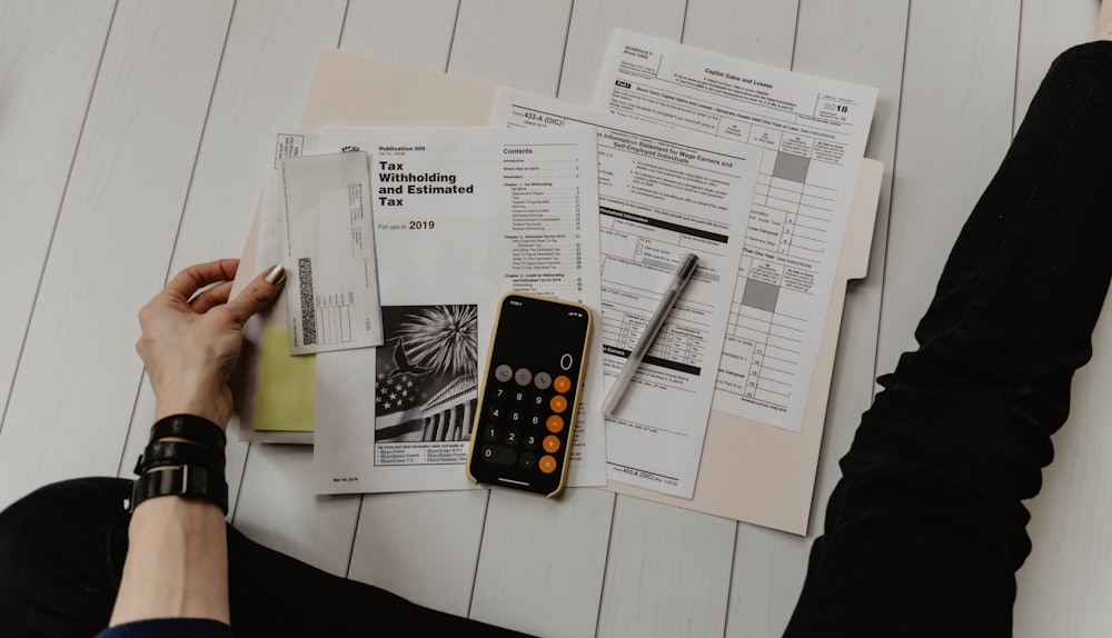 Tax forms with a calculator and pen on a desk